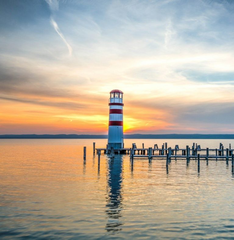 Sunset Waves Dramatic orange sunset sky with sun visible through clouds over silhouetted breaking waves.